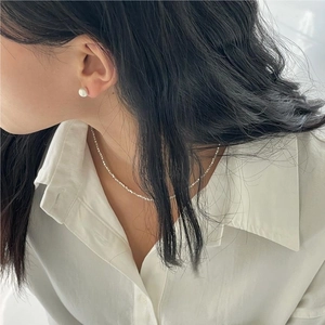 Detail showing 925 sterling silver brushed bead earrings and pearl necklace on a model