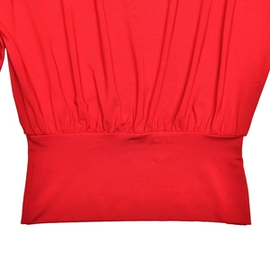 Detailed macro view of red pleated waist design on a slim-fit long-sleeve knit top