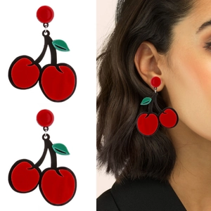 Macro view of red acrylic cherry earrings with green leaves and a model wearing the jewelry