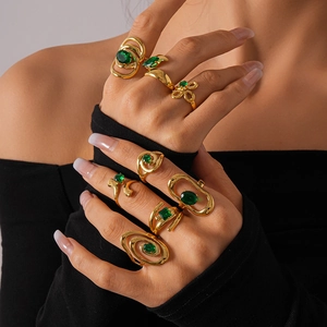 Detail of vintage gold-plated rings set with green zircon stones on model's hand