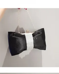 Detail der schwarzen Satin-Schleifen-Clutch mit glitzernder Strassmitte und silberner Kette
