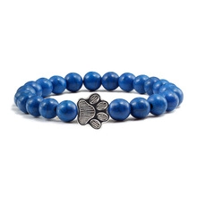 Detailed view of natural stone beaded bracelet with a silver metal paw print charm