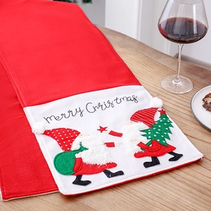Red Christmas table runner with Santa Gnomes and Merry Christmas embroidery on wooden table
