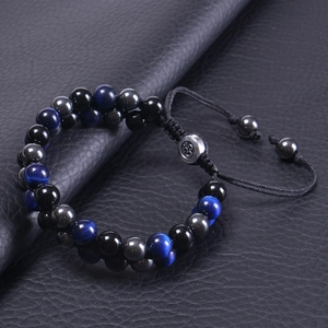 Macro shot of double-layered blue tiger eye and obsidian beaded bracelet on leather background