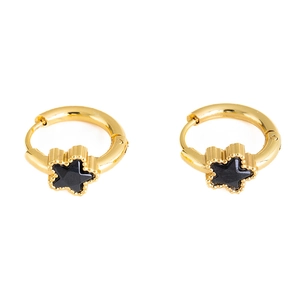 Close-up of gold star earrings with black enamel pendant and beaded edge detail
