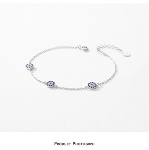 Detail of S925 silver evil eye bracelet with blue crystals and heart tag