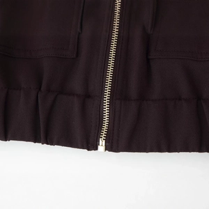 Detailed view of dark coffee canvas jacket featuring a metal zipper and ribbed hemline