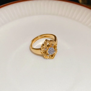 Close-up of a 24K gold-plated cutout flower ring with sparkling zircon insets