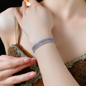 Détail d'un bracelet à quatre rangées de zircons violets et blancs sur fond vintage chaleureux