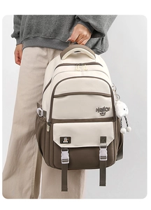 Detail view of large capacity student backpack with contrast color and plush pendant