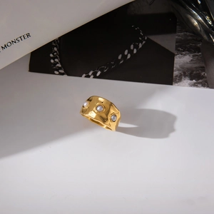 Macro detail of wide gold hammer-textured ring featuring three inlaid white pearls
