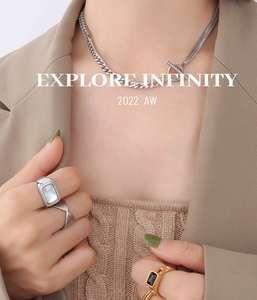 Detalle del collar con cierre OT y circonitas junto a anillos de diseño elegante