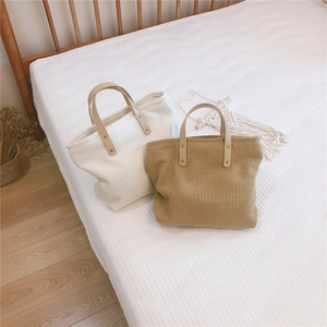 Detail of waffle weave texture tote bags with leather handles and metal rivets