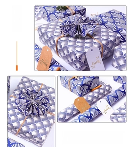 Detail of blue fan pattern gift wrap with hemp rope and Cheers decorative tag