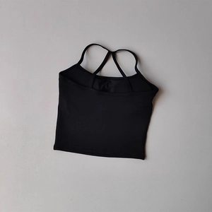 Détail du haut de yoga noir montrant les bretelles croisées et le tissu élastique respirant