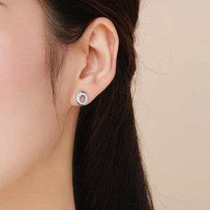 Boucles d'oreilles ovales en argent 925 avec cristaux blancs portées par un mannequin
