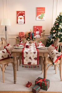 Christmas table runner with deer and snowflake patterns featuring festive red tassels