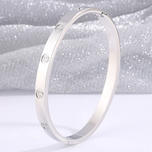 Detail shot of silver stainless steel bangle with sunburst pattern and polished finish