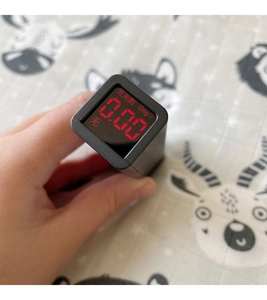 Macro view of a handheld digital fluorescent agent tester with red LED display on a soft cloth