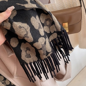 Detailed view of leopard print scarf corner with fringe and soft cashmere-like texture