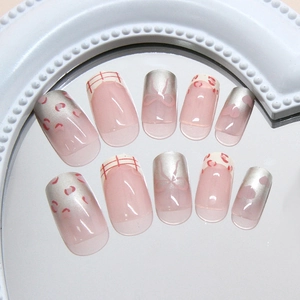 Pink heart leopard bow press-on nails set with metallic accents on a mirror surface