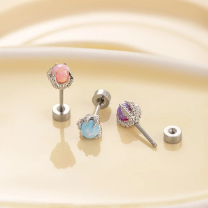 Titanium dragon claw earrings with pink blue and purple opal stones on a tray