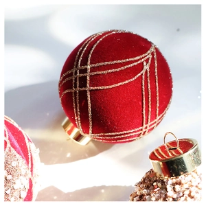 Detail of red velvet Christmas ball ornament with gold glitter grid pattern and metal cap