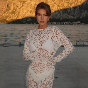 Close-up of white lace embroidery texture on long sleeve dress for beach vacation wear