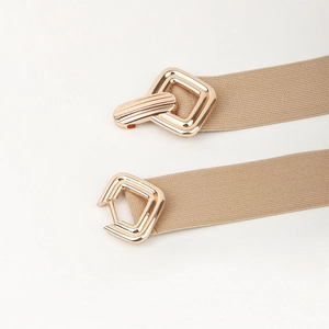 Gros plan sur la boucle géométrique dorée et la texture de la ceinture élastique kaki