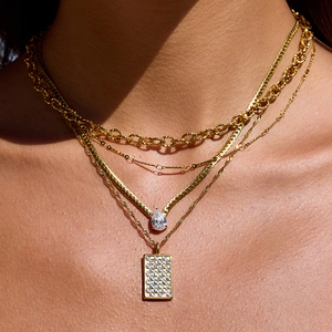 Layered gold rhinestone necklace set featuring pear and rectangle crystal pendants on model