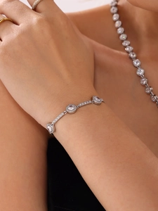 Close-up of sparkling round zircon link bracelet with matching luxury jewelry set on model