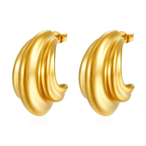 Detail of layered gold starfish wave earrings with a triple-layered curved metal design