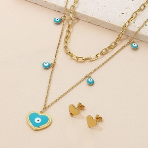 Detail of gold double-layer necklace with blue evil eye pendants and matching heart earrings
