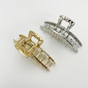 Detail of large woven gold and silver alloy hair claws with hollow geometric patterns