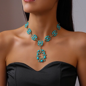 Gros plan du collier en or vintage avec pierres turquoises ovales et micro-diamants brillants