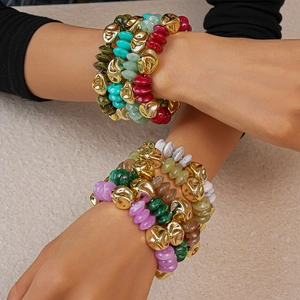 Detail of layered acrylic beaded bracelets with colorful marble textures and gold metal accents