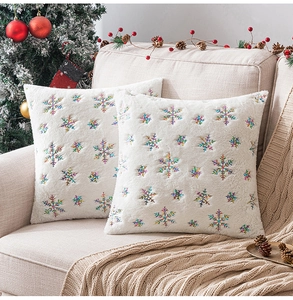Detailed embroidery of colorful snowflakes on plush white Christmas pillowcases