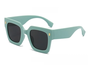 Detail shot of square mint green sunglasses with dark lenses and gold metal accents
