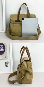 Detail of khaki canvas bag showing leather handles, metal hooks and tablet storage capacity