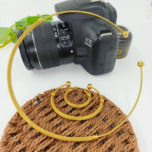 Macro detail of golden mesh texture collar necklace and matching ball earrings jewelry set