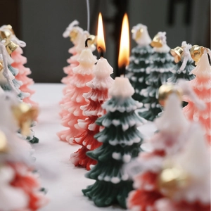 Christmas tree scented candles with snow-tipped leaves and festive gold bells