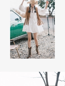 Outdoor lifestyle shot of a beige cowboy hat with a bohemian vest and vintage car
