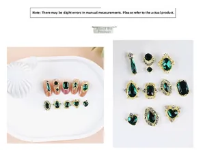 Detailed view of dark green gemstone nail charms in gold alloy frames for nail art