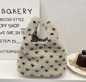 Détail du sac à main en peluche à motifs de cœurs bleus et doublure à carreaux noirs et blancs