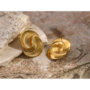 Detail of 18k gold stainless steel spiral earrings with drop texture on natural stone