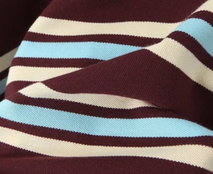 Close-up of soft striped knit fabric in burgundy, light blue, and beige colors
