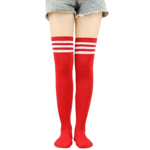 Detail of red over-the-knee socks featuring three white stripes and fine knitted texture