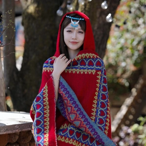 Détails de la maille du châle ethnique rouge avec motifs de cœur bleus et broderies