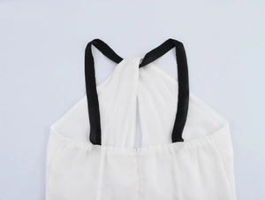 Détail du dos avec bretelles noires et fermeture éclair invisible sur robe blanche