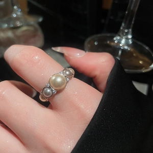 Close-up of elegant French vintage ring featuring pearls and zircon on a silver band